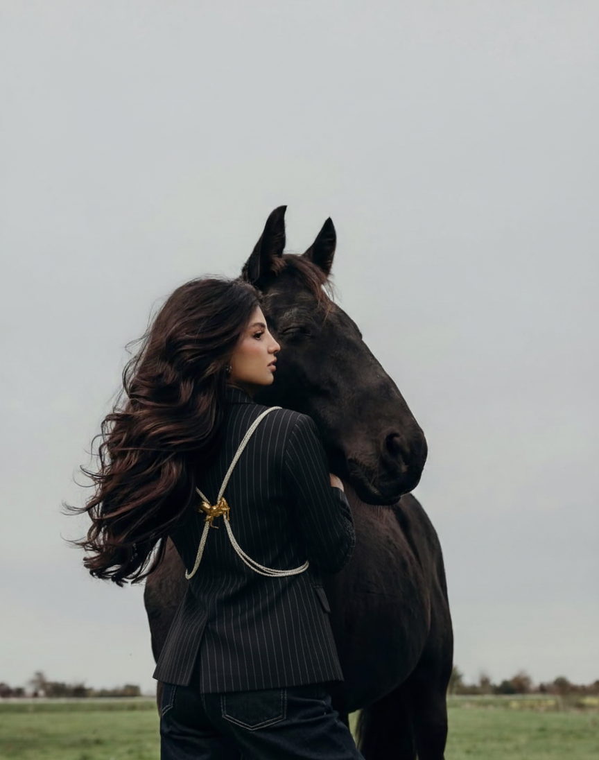 Woman standing next to a horse in an open field with 'Kuch Alag' branding.